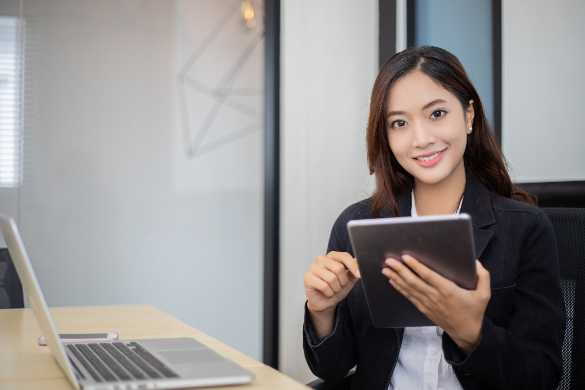 Asian business women using tablet for working at office relax t