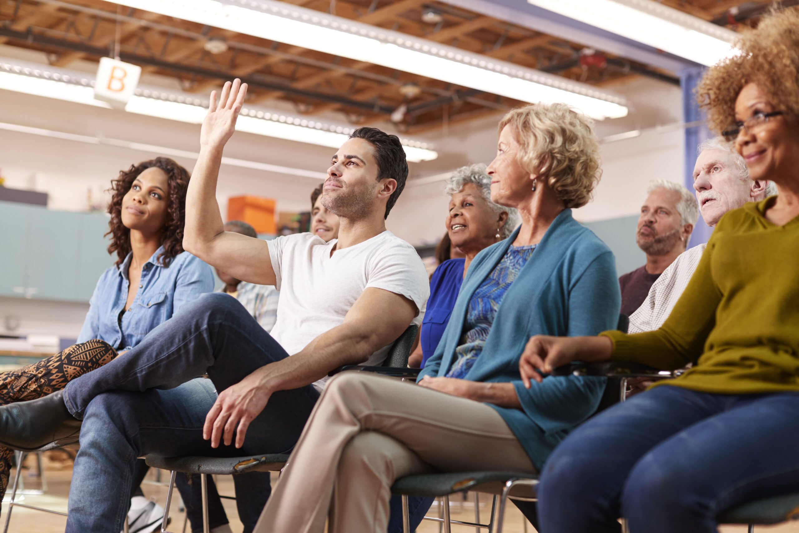 Man Asking Question At Neighborhood Meeting In Community Center