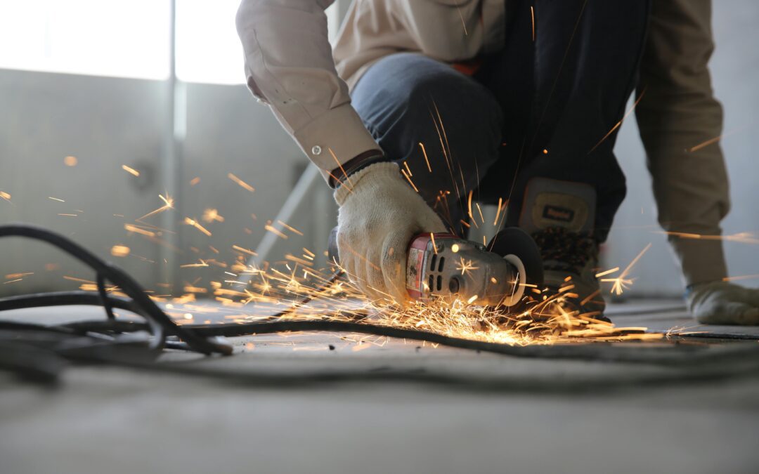 Construction zone close up of a worker using a grinder on metal.